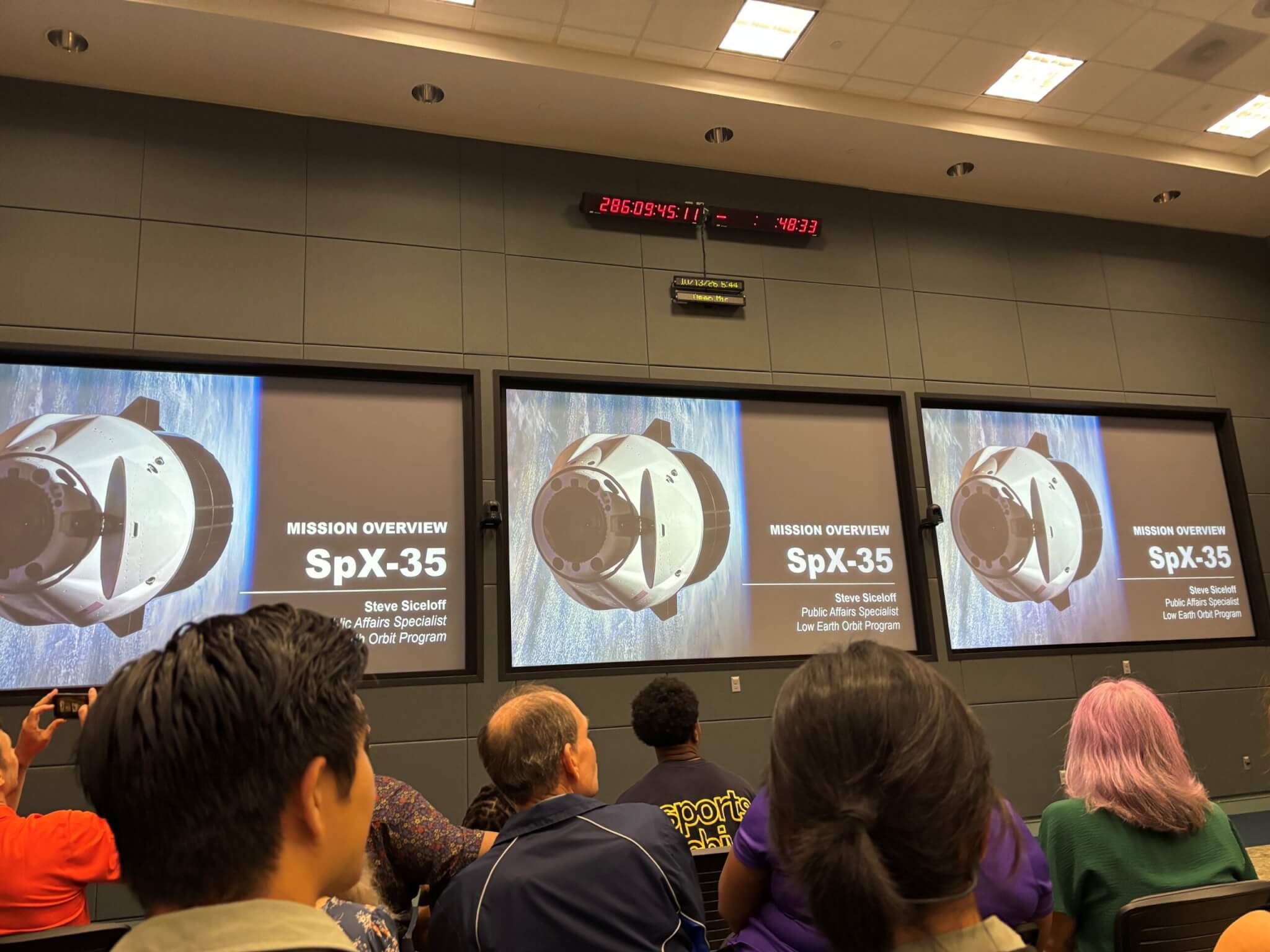 NSCF and other team members attend the pre-launch presentation on research flying on SpaceX CRS-35. The briefing was held in Kennedy Space Center’s viewing room at OSB II, with the countdown clock visible at the top of the photo. Photo Courtesy of NSCF.